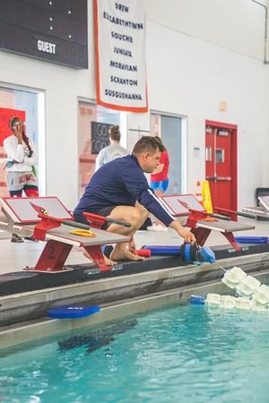 Coach working with an adult swimmer on stroke technique