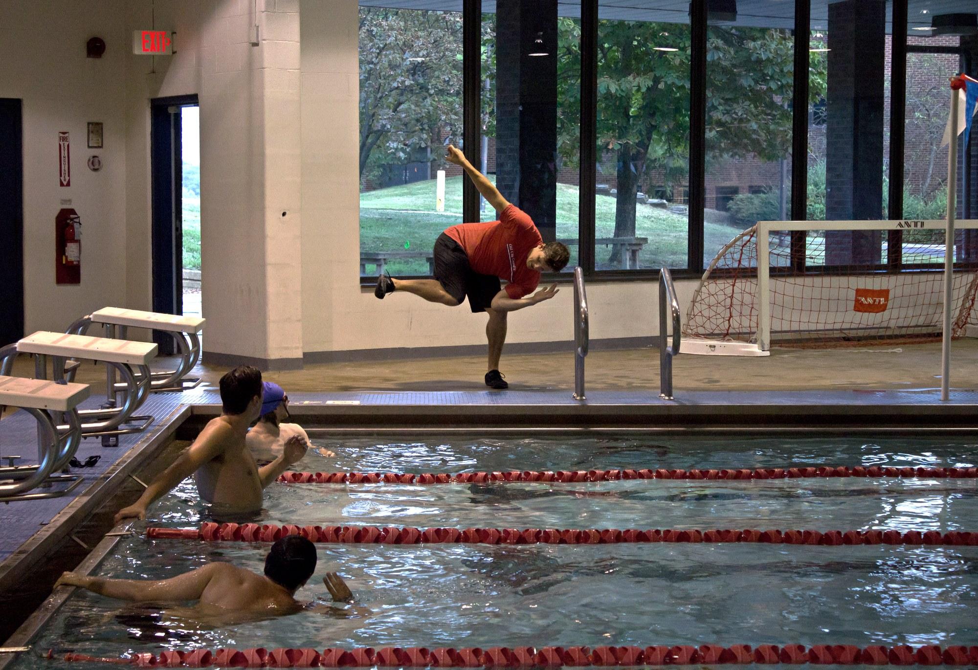 Coach Sean demonstrating a balance position on the pool deck for adult swimmers in the lanes